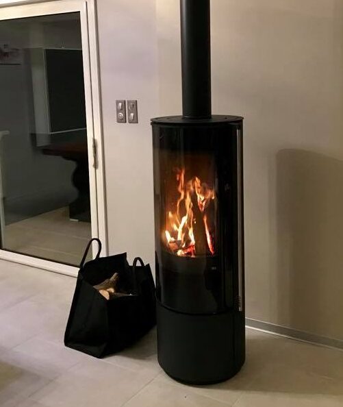 Poêle à bois moderne avec flammes, chez Cheminées des Pyrénées à Séméac, ambiance chaleureuse et contemporaine,