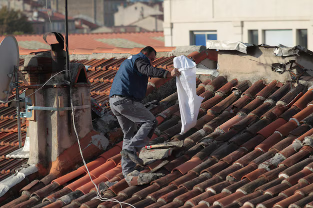 Technicien Cheminées des Pyrénées inspectant un toit à Séméac près d'une cheminée moderne en plein jour,
