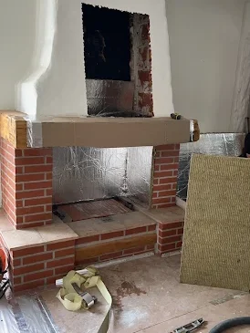 Cheminée en rénovation chez Cheminées des Pyrénées à Séméac avec briques, crépi blanc et protection thermique,