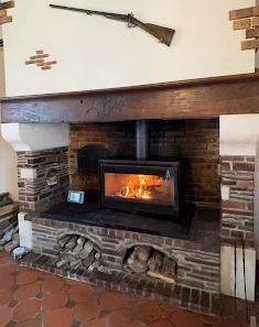 Cheminée rustique en briques avec poutre bois par Cheminées des Pyrénées à Séméac, ambiance chaleureuse,
