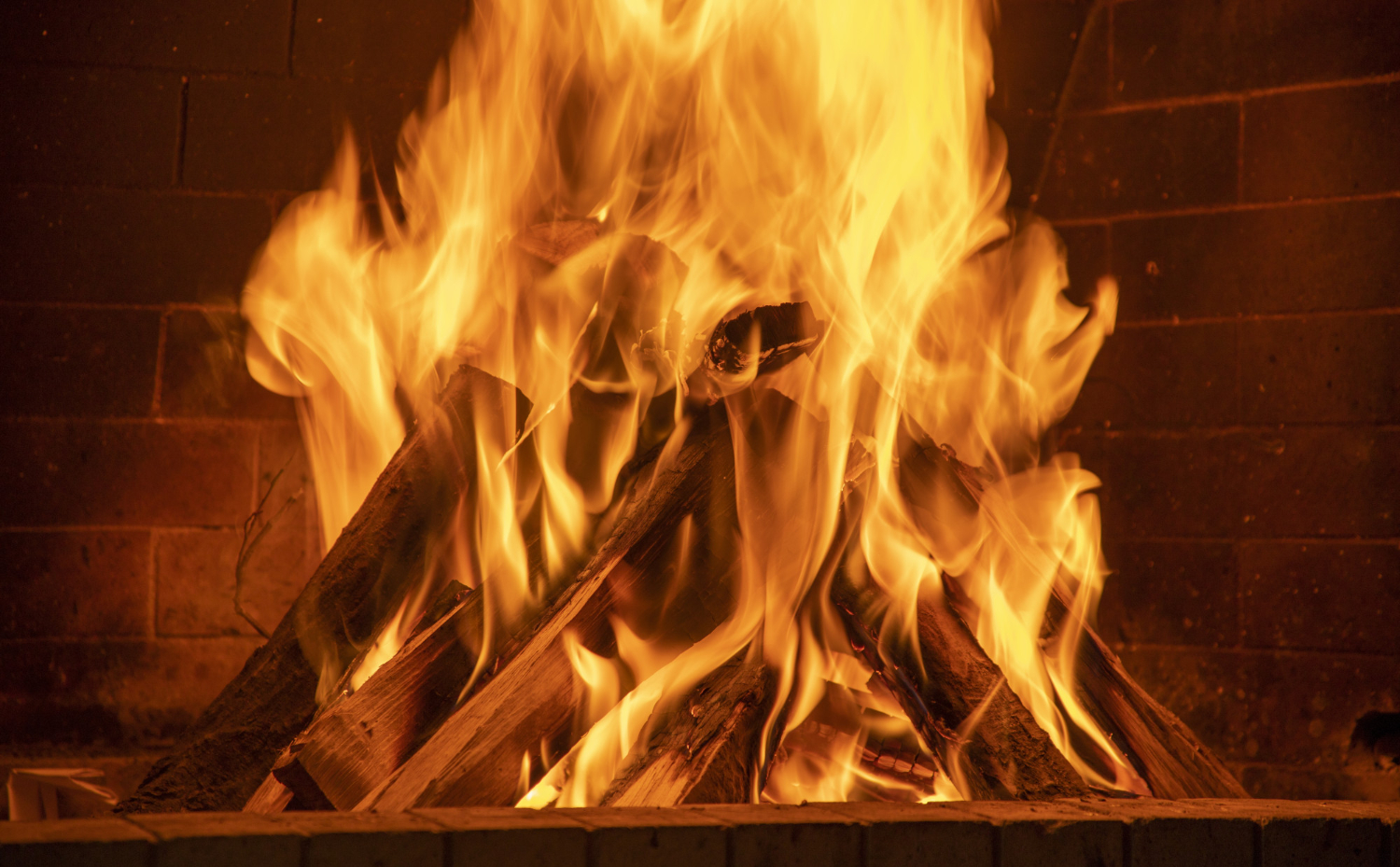 Feu de bois chaleureux dans une cheminée chez Cheminées des Pyrénées à Séméac, ambiance conviviale hiver,