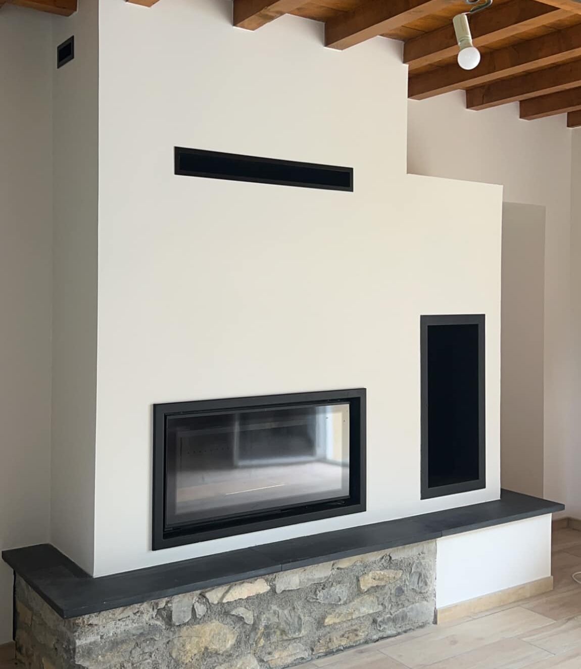 Cheminée contemporaine Cheminées des Pyrénées à Séméac avec vitre noire et plafond bois chaleureux,
