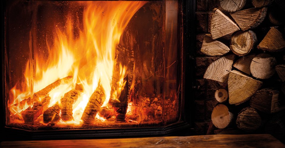Ambiance chaleureuse avec foyer bois Cheminées des Pyrénées à Séméac et pile de bois rangée,
